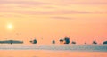 oil tanker ships and fishing boats sailing in the sea against golden sunrise sky background in the morning Royalty Free Stock Photo