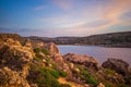 Beautiful sunset and seascape view with mountains of Golden Bay, Malta, travel background Royalty Free Stock Photo