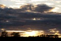 Beautiful sunset, the setting sun on a background of purple storm clouds. Dark clouds hide the rays of light coming from behind Royalty Free Stock Photo