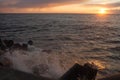 Beautiful sunset on the shore of a sandy beach. Waves on the Baltic Sea.