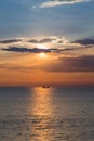 Beautiful sunset sky over small fishing boat over seacoast skyline Royalty Free Stock Photo