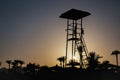 Beautiful sunset sky with silhouette lifeguard tower and coconut palm trees. Abstract nature and travel background