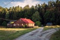 A beautiful sunset in a small village bordering the forest. A small country house illuminated by the sun. KrasnobrÃÂ³d, Poland