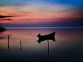 Beautiful sunset/sunrise over water and silhouette fishing boat Royalty Free Stock Photo