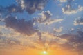 Beautiful sunset or sunrise with sun and orange, grey clouds on the blue sky Royalty Free Stock Photo