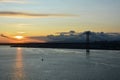 Beautiful sunset. Tejo river. 25th April bridge. Lisbon. Portugal. Almada. Clouds. Yacht. Boat. Sun. Colourfully. Light. Sunlight.