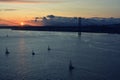 Beautiful sunset. Tejo river. 25th April bridge. Lisbon. Portugal. Almada. Clouds. Yacht. Boat. Sun. Colourfully. Light. Sunlight