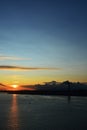 Beautiful sunset. Tejo river. 25th April bridge. Lisbon. Portugal. Almada. Clouds. Yacht. Boat. Sun. Colourfully. Light. Sunlight.