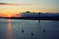 Beautiful sunset. Tejo river. 25th April bridge. Lisbon. Portugal. Almada. Clouds. Yacht. Boat. Sun. Colourfully. Light. Sunlight.