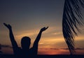 Beautiful sunset in the tropics with silhouettes of a man with his palms raised to the sky Royalty Free Stock Photo