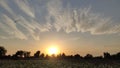 Beautiful sunset view with agricultural field and designed clouds in the sky