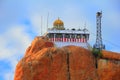 Beautiful sunset view of ancient Hindu Siva Temple at the top of barren rock against the background of cloudy blue sky in Trichy