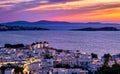 Beautiful sunset view of famous traditional white windmills on hilltop, Mykonos, Greece. Whitewashed houses, sunset sky Royalty Free Stock Photo