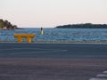 A beautiful sunset view of a horizon with two islands. A large yellow bollard in the foreground