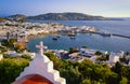 Beautiful sunset view, Mykonos, Greece from red roof top of Greek Orthodox church. Bay, ships, whitewashed houses