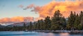 Beautiful sunset views of the shoreline of South Lake Tahoe, houses visible among pine trees Royalty Free Stock Photo