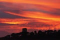 Beautiful sunset in Villajoyosa, Costa Blanca, Spain. Dark silhouette of old tower on the hill and red sky background Royalty Free Stock Photo