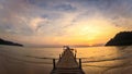 beautiful sunset at the wooden jetty at the beach. Wood bridge on the sea which has walk way for travel with beautiful sky and Royalty Free Stock Photo