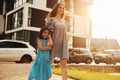 Beautiful sunshine. Young mother with her little daughter walking near the buildings Royalty Free Stock Photo