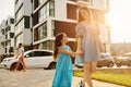 Beautiful sunshine. Young mother with her little daughter walking near the buildings Royalty Free Stock Photo