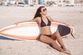 Beautiful surfer brunette girl with board relaxing on the beach of Dubai Royalty Free Stock Photo