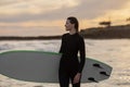 Beautiful Surfer Woman With Her Surfboard Standing On The Beach At Sunset Royalty Free Stock Photo