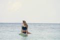 Surfer girl sitting on surfboard in water at the beach. Maldives Royalty Free Stock Photo