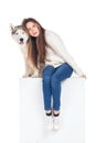 beautiful surprised girl sitting on white cube with husky dog Royalty Free Stock Photo