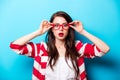 Beautiful surprised young woman in glasses standing in front of