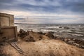 Beautiful surreal landscape of abandoned house and ladder on rocky seashore at sunset time. Cloudy weather. Caspian Sea, Azerbaija Royalty Free Stock Photo