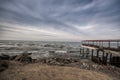 Beautiful surreal landscape of abandoned house and ladder on rocky seashore at sunset time. Cloudy weather. Caspian Sea, Azerbaija Royalty Free Stock Photo