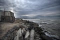 Beautiful surreal landscape of abandoned house and ladder on rocky seashore at sunset time. Cloudy weather. Caspian Sea, Azerbaija Royalty Free Stock Photo