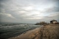 Beautiful surreal landscape of abandoned house and ladder on rocky seashore at sunset time. Cloudy weather. Caspian Sea, Azerbaija Royalty Free Stock Photo