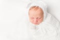 Beautiful swaddled baby in white closeup