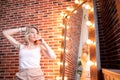 Beautiful swag style dressed girl in short jeans at textured red bricks wall background Royalty Free Stock Photo