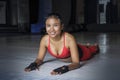 Beautiful sweaty Asian woman in sport clothes stretching on gym dojo floor smiling posing corporate