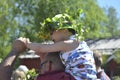 Beautiful swedish people and kids are enjoying traditional decoration of mid summer day wearing crown made of leaves in sunny day