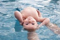 Beautiful, sweet baby boy swimming in the swimming pool holding fathers hands. Royalty Free Stock Photo