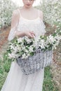 Beautiful sweet gentle happy girl in a beige boudoir dress with flowers in a basket holding , photo processing in the style of mod Royalty Free Stock Photo