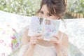 Beautiful sweet gentle happy girl in a beige boudoir dress with flowers in a basket holding , photo processing in the style of mod