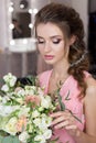 Beautiful sweet girl bridesmaid preparing for the wedding of a friend in the pink evening dress with evening hairstyle and bright Royalty Free Stock Photo