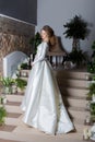 beautiful sweet girl elegant bride in an elegant wedding dress standing on the stairs Royalty Free Stock Photo