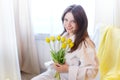 Beautiful sweet girl in nightgown in early morning with bouquet of delicate yellow tulips. Gift on International Royalty Free Stock Photo