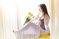 Beautiful sweet girl in nightgown in early morning with bouquet of delicate yellow tulips. Gift on International Royalty Free Stock Photo