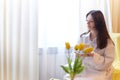 Beautiful sweet girl in nightgown in early morning with bouquet of delicate yellow tulips. Gift on International Royalty Free Stock Photo