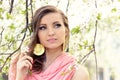 Beautiful sweetheart elegant girl in a pink jacket near the tree with white flowers with the wind in your hair Royalty Free Stock Photo