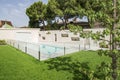 Beautiful swimming pool of a luxury detached house with marble tiles and a wall with niches to accommodate outdoor plants, glass