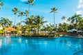 Beautiful swimming pool surrounded by palm trees under the blue sky Royalty Free Stock Photo