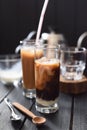 Beautiful swirls of coconut milk in Vietnamese iced coffee in tall glasses on dark background