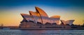 Beautiful Sydney Opera House at sunset shadowed by Sydney Harbor Bridge